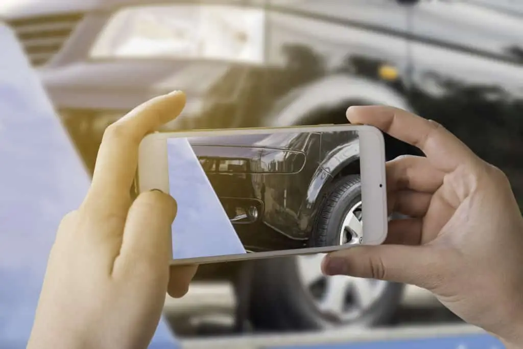 Taking photos of a vehicle with damage.