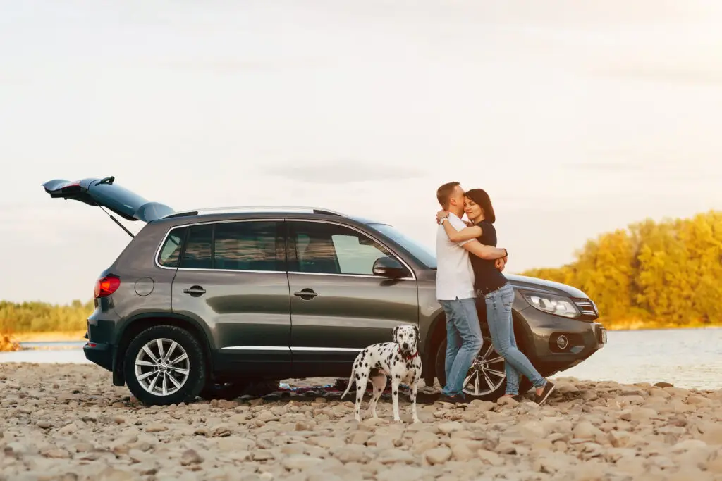 Family and dog embrace after having car delivered by smart auto move
